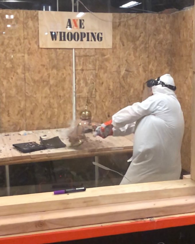 A customer in the rage room at Axe Whooping — an ax-throwing location that also offers a rage room — in central Denver.